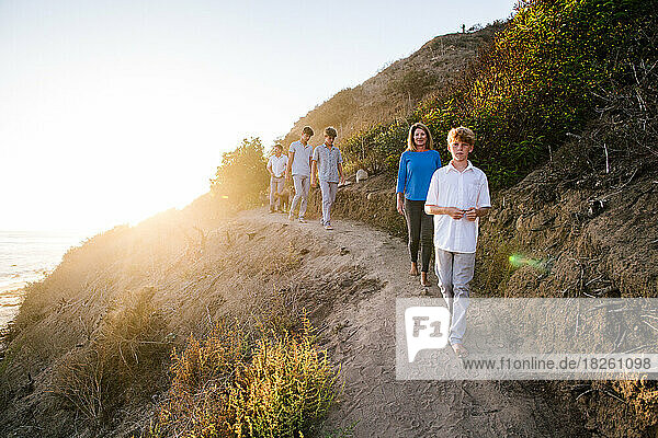 Family Walks On A Trail Above The Beach