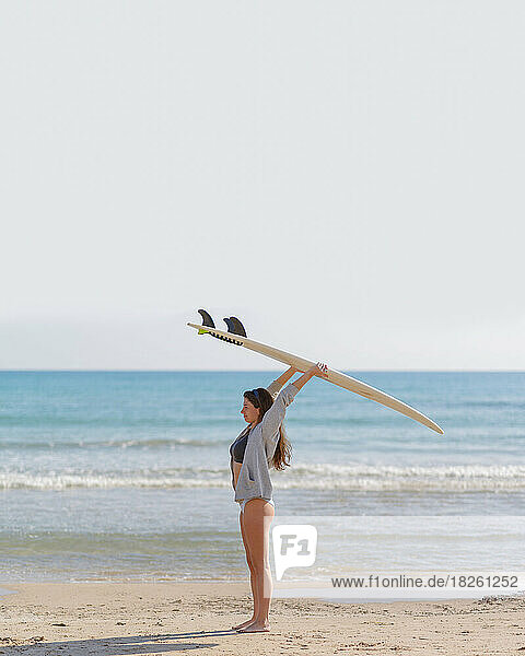 young woman with surfboard on the beach