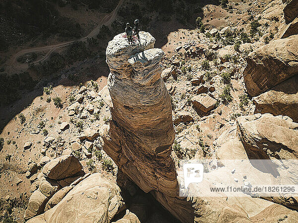 Drone shot of man and woman standing on rock tower at Bride Canyon