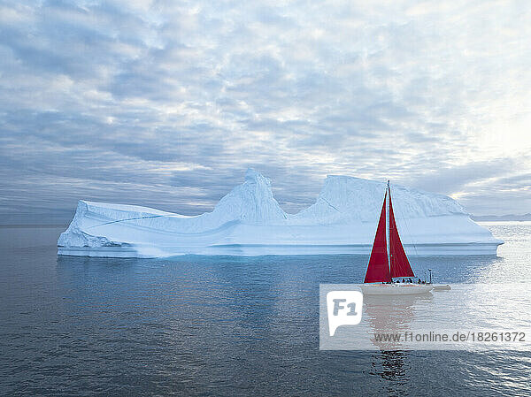 small sailboat near big icebergs from aerial point of view