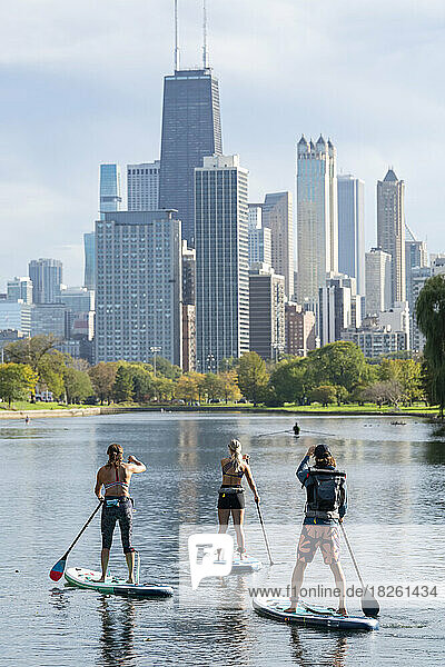 male and female friends paddleboarding in river
