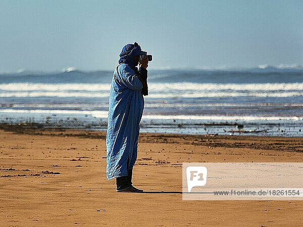 Fotograf  Berber in typischer blauer Kleidung fotografiert am Strand  Plage Tagharte  Essaouira  Atlantik  Maro