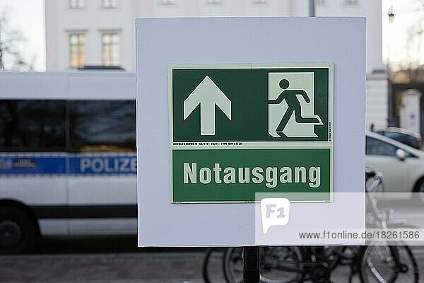 Im Vordergrund ein Schild vom Notausgang  im Hintergrund ein Polizeiauto  Berlin  Deutschland  Europa