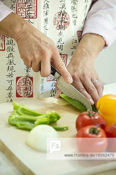 Adult male cutting vegetable in the kitchen