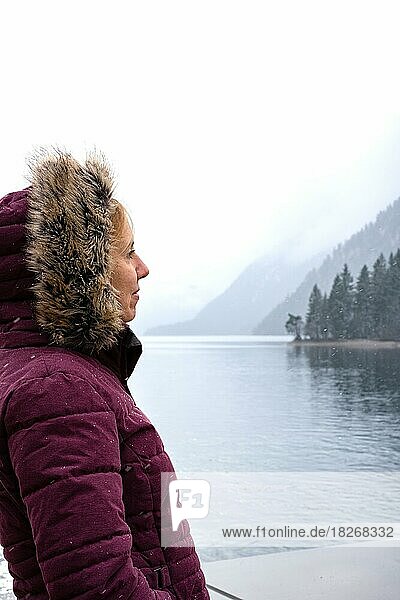 Frau steht vor vernebeltem See im Winter bei Schnee  Achensee  Tirol  Österreich  Europa