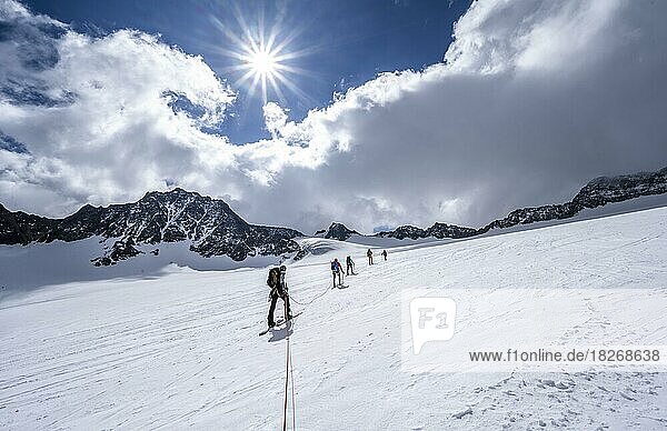 Group of ski tourers ascending on the rope  at Alpeiner Ferner  ascent to Obere Hölltalscharte  Sonnenstern  Stubai Alps  Tyrol  Austria  Europe