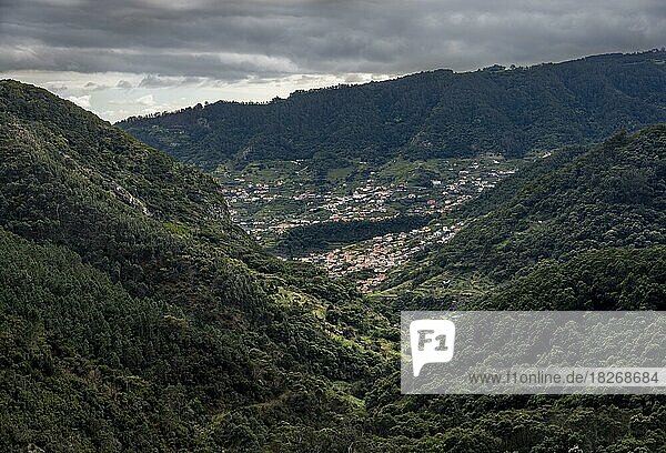Dicht bewaldete Berge  hinten Häuser des Ortes Machico  Wanderweg Vereda do Larano  Madeira  Portugal  Europa