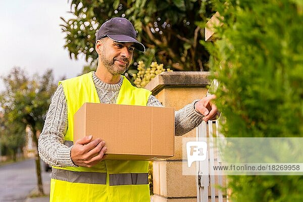 Paketzusteller mit einem Karton eines Online-Shops  klingelnd  Kopierraum