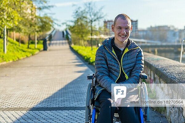Porträt einer behinderten Person im Rollstuhl  die sich in einem Stadtpark vergnügt