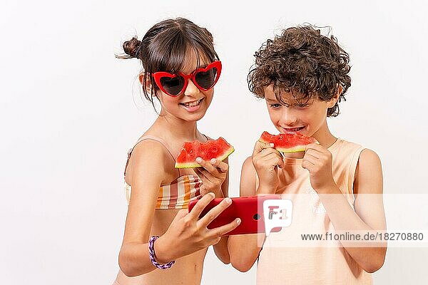 Kinder genießen den Sommer  essen eine Wassermelone und machen ein Selfie mit dem Telefon. Weißer Hintergrund