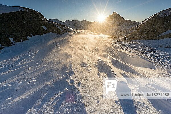 Winterlandschaft in den Bündner Bergen mit auffrischendem Wind beim Sonnenaufgang  Kanton Graubünden  Schweiz  Europa
