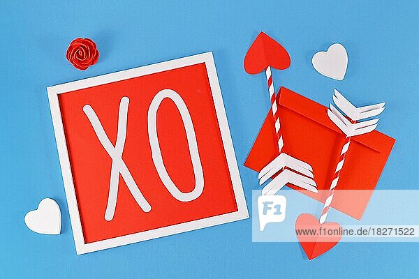 Valentinstag Komposition mit Bilderrahmen mit Text XO  Amor Liebe Pfeile  Brief  und Herzen auf blauem Hintergrund