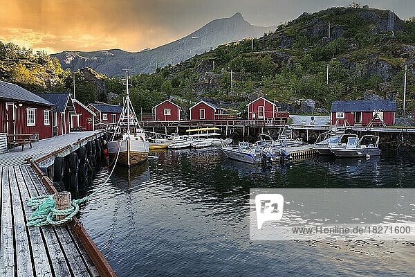 Rote Fischerhütten und Boote im Freilichtmuseum  Fischerdorf Nusfjord  Abendhimmel  Lofoten  Norwegen  Europa