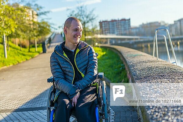 Porträt einer behinderten Person im Rollstuhl  die sich in einem Stadtpark vergnügt
