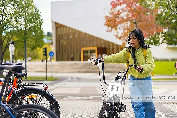 Young asian female student parking the bike in university campus  healthy and green life