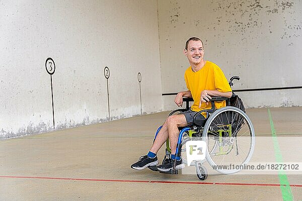 Eine behinderte Person im Rollstuhl bei einem baskischen Pelota-Spiel lächelt