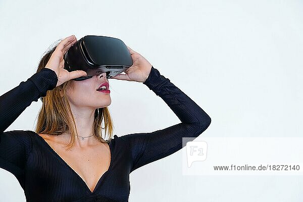 Frau mit Virtual-Reality-Brille auf weißem Hintergrund  futuristisches Konzept  Metaverse  lächelnd