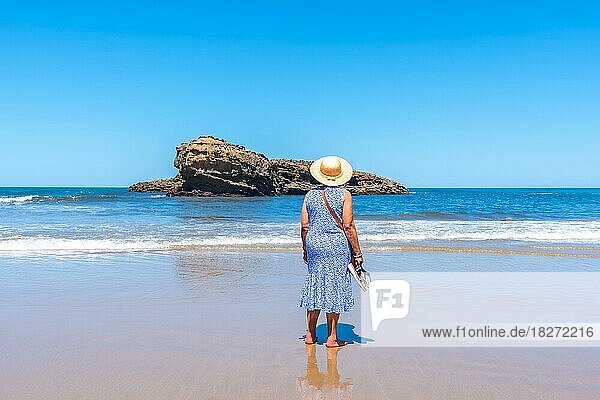 Eine ältere Frau im Urlaub schaut am Strand von Biarritz  Lapurdi  auf das Meer. Frankreich  südwestlicher Badeort