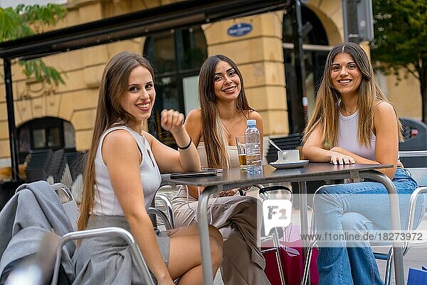 Porträt von Freundinnen  die an einem Nachmittag auf der Terrasse einer Cafeteria etwas trinken