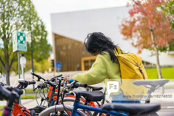 Asian female student parking the bike in college campus  healthy and green life