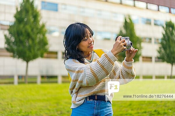 Asian young woman photography with a vintage photo camera visiting a city park  backpacker traveler concept
