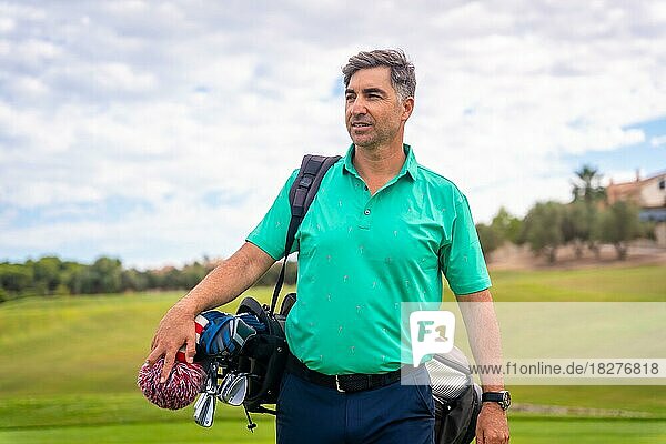 A professional golf player on a golf course  walking towards the tee
