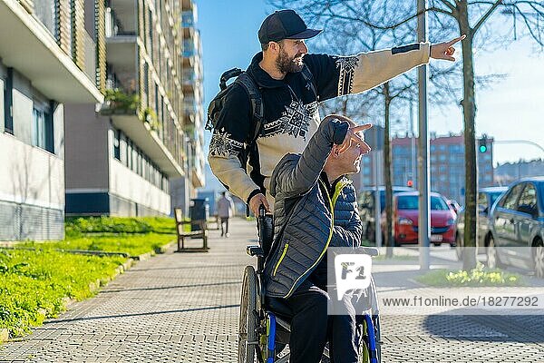 Eine behinderte Person im Rollstuhl geht mit einem Freund im Rollstuhl auf der Straße spazieren