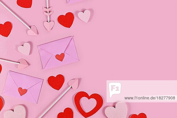 Valentinstag flach legen mit Liebe Buchstaben  Amor Pfeile und rote Herzen Konfetti auf rosa Hintergrund