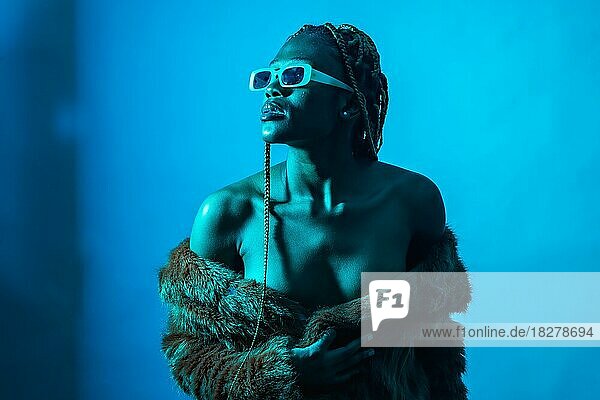 Attractive black ethnic woman with braids with blue led lights  trap dancer with seductive look
