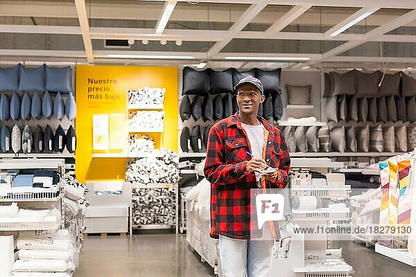 Black ethnic man shopping in a supermarket for almeadas and cushions
