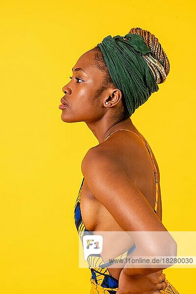 Eine weibliche Person schwarzer Volkszugehörigkeit in Tracht auf gelbem Hintergrund  seriöses Profilmodell