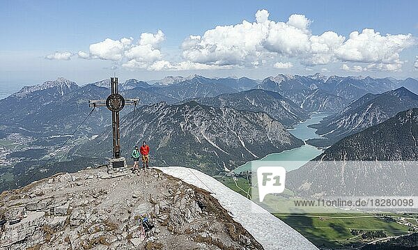 Two hikers at the summit  aerial view  mountain panorama  view from Thaneller to Plansee and eastern Lechtal Alps  Tyrol  Austria  Europe