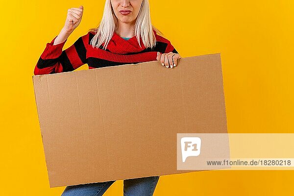 Demonstrieren mit leeren Karton Werbeplakat  blonde kaukasische Mädchen auf gelbem Hintergrund Studio