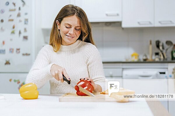 Vegetarische Frau beim Zubereiten eines Gemüsesandwichs in der Küche zu Hause