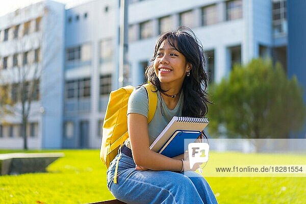 Asiatisches Mädchen auf dem Campus  Studentin genießt den Unterricht  lächelnd im College  sitzend lächelnd