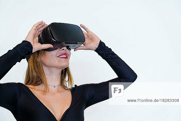 Woman with virtual reality glasses on white background  futuristic concept  metaverse  smiling holding the glasses