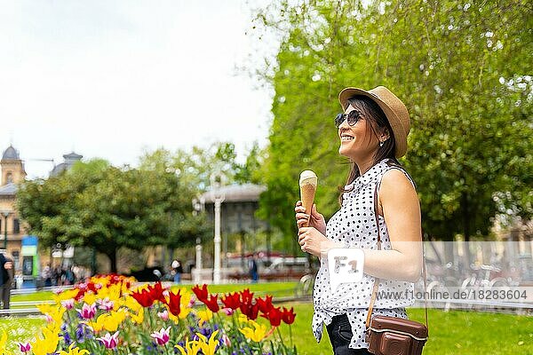 Ein Tourist Frau zu Fuß besuchen die Stadt essen ein Eis  genießen Sommerferien und mit einer Kamera  Solo weibliche Reisende Konzept