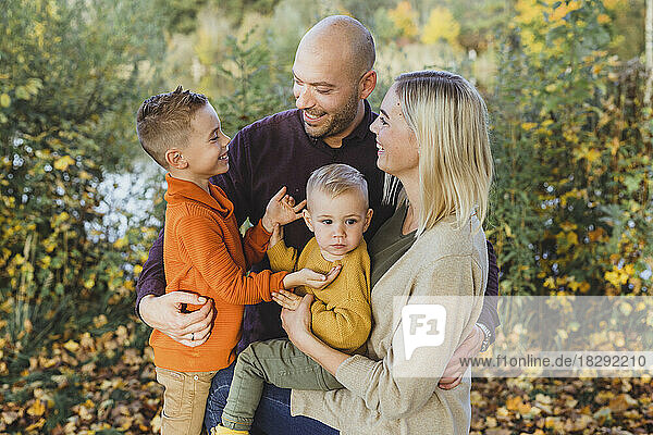 Smiling parents with sons in autumn