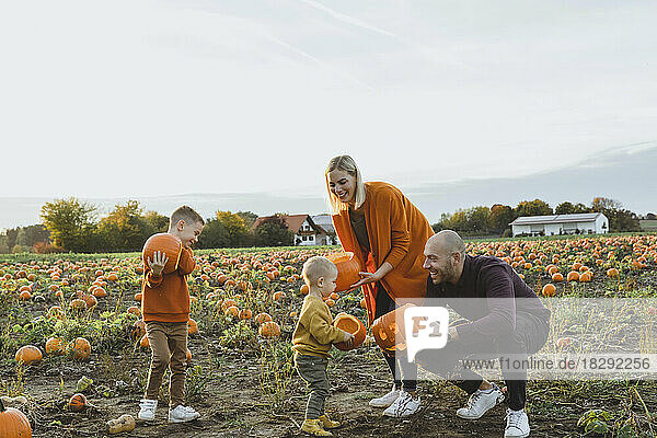 Happy family holding jack o' lanterns in field