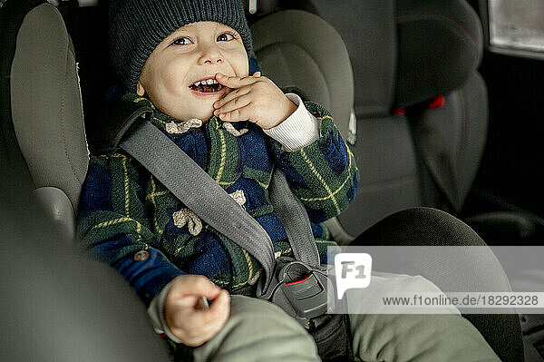Glücklicher Junge im Autosicherheitssitz