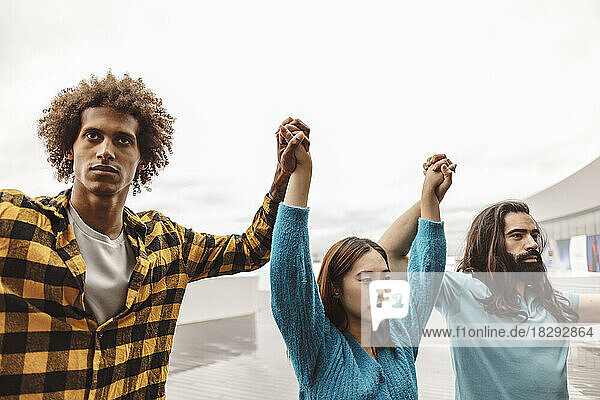 Multiracial activists holding hands standing with each other