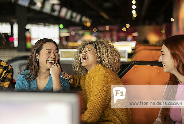 Woman with friends laughing at bowling alley
