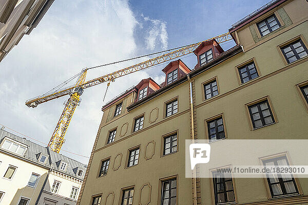 Germany  Bavaria  Munich  Industrial crane looming over apartment building