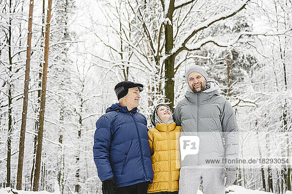 Glücklicher Junge mit Vater und Großvater  der den Winter im Park genießt