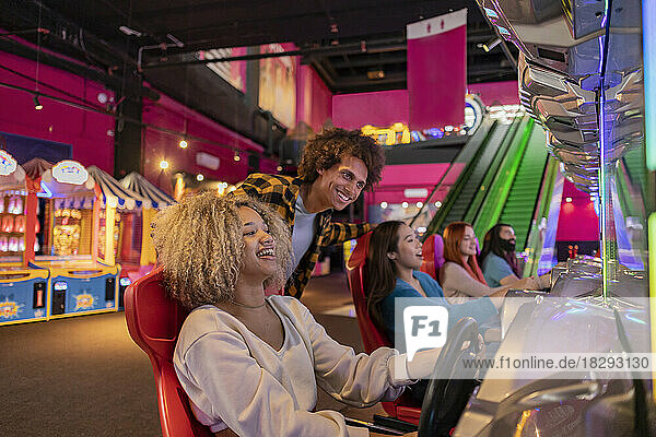 Woman playing and having fun with a driving simulator in an amusement arcade