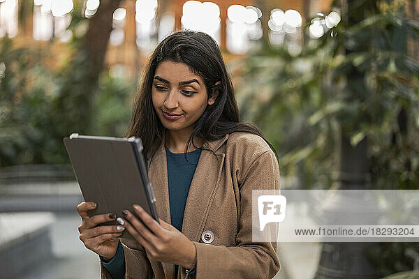 Woman looking at tablet PC on footpath