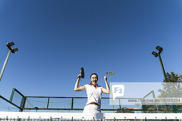 Aufgeregte Frau jubelt an einem sonnigen Tag auf dem Sportplatz