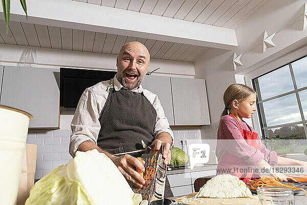 Happy father and daughter preparing healthy meal in kitchen at home
