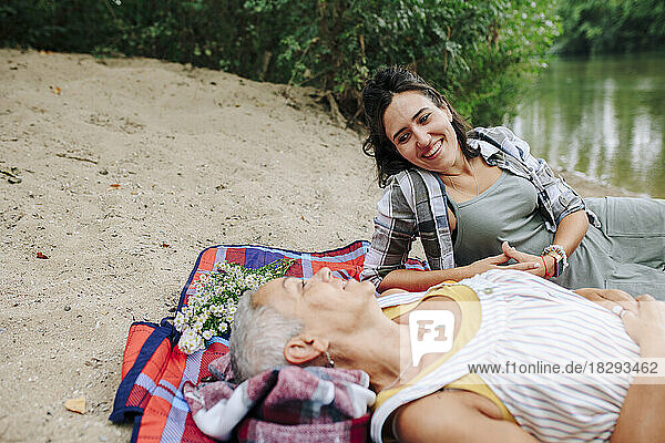 Happy women relaxing near lake at park