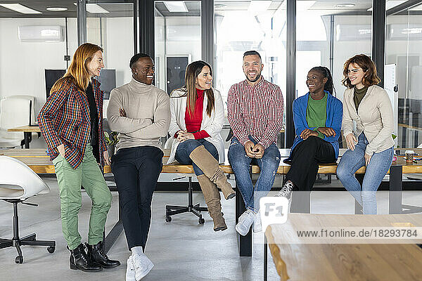 Happy multiracial businessmen and businesswomen spending time together in coworking office